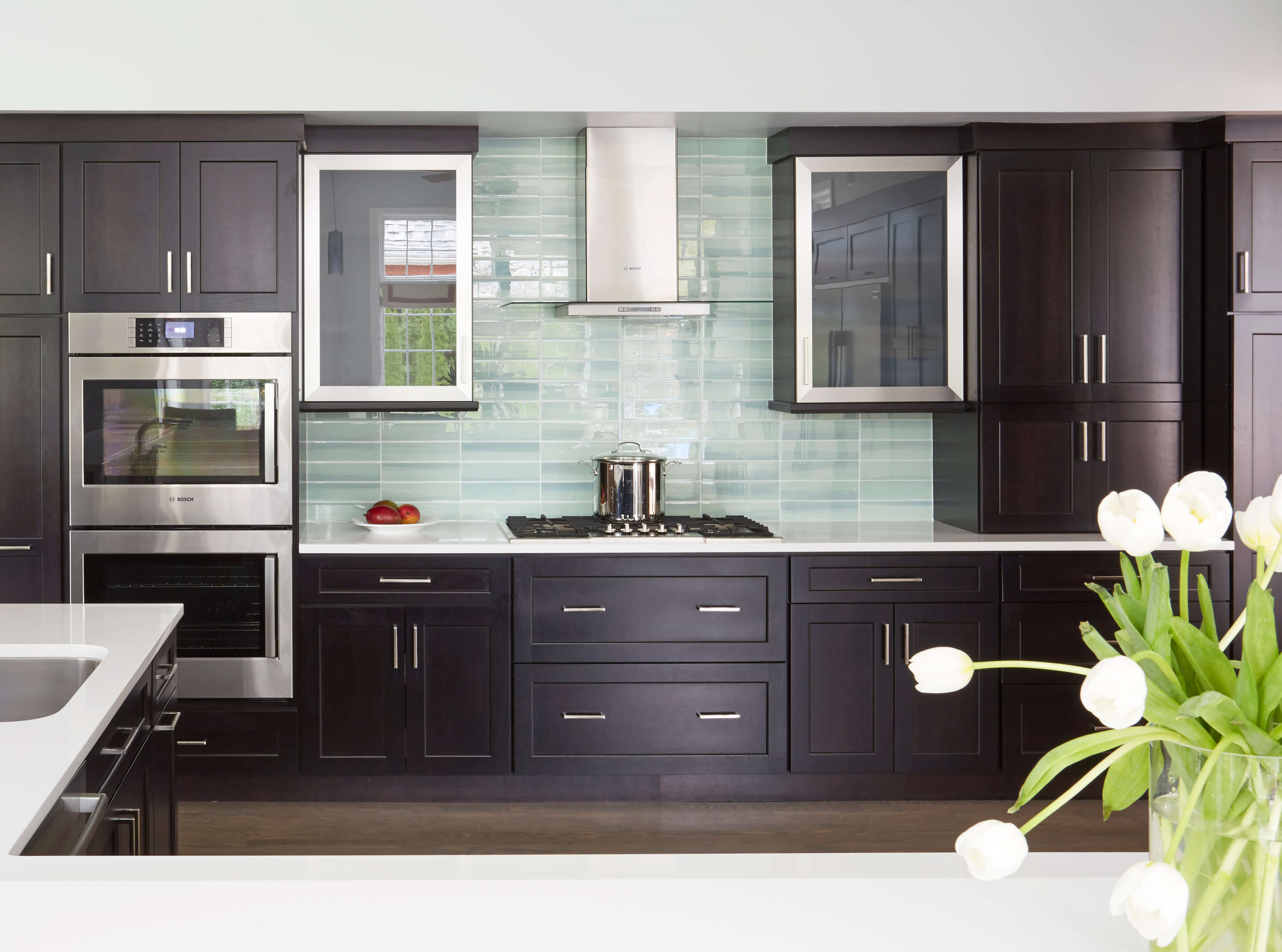 A black contemporary kitchen with almost black stained slab style cabinets.
